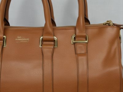 Professional cleaning of leather handbag showing stain removal and conditioning results