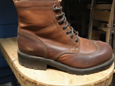Boot repair showing sole replacement and upper restoration work